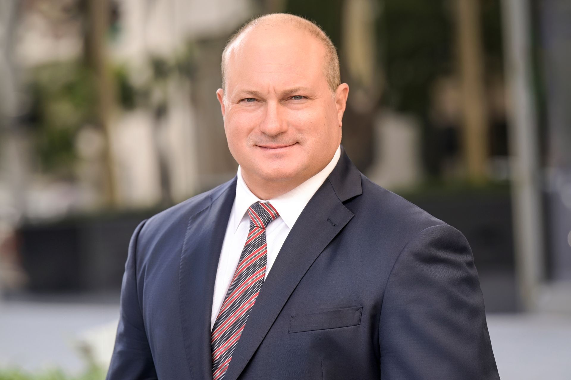 A man in a suit and tie is smiling for the camera.