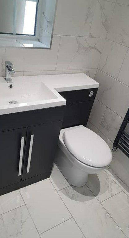 Picture of a white toilet and dark blue vanity unit fitted by Plumbers Sheffield