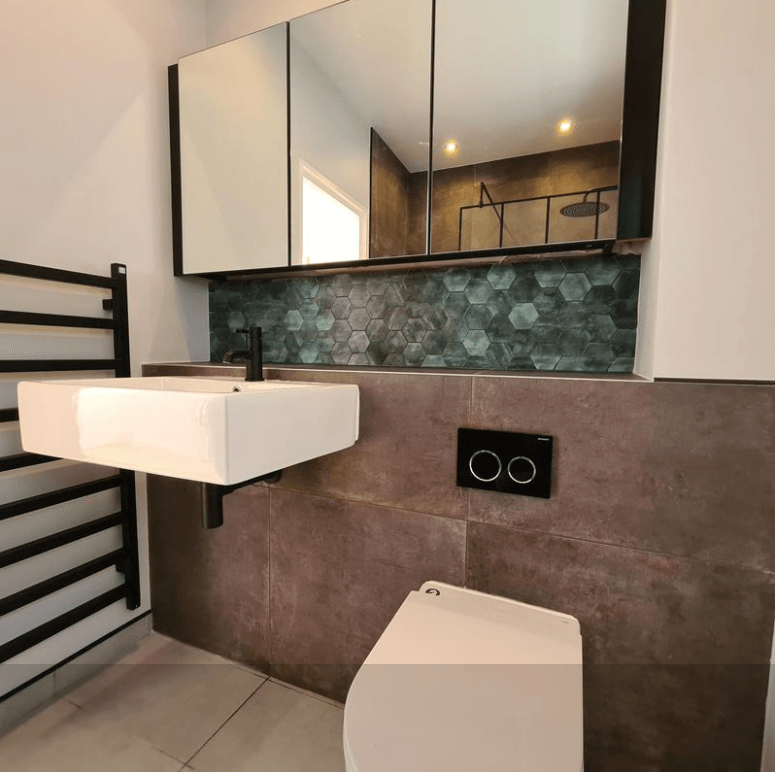 Picture of a new bathroom in with dark green mosaic tiles and white sanitary ware by Plumbers Sheffield