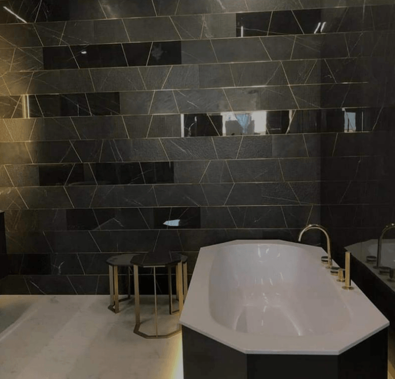 Picture of a new bathroom fitted by plumbers Sheffield with black tiles and gold accessories