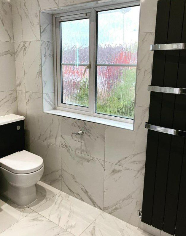 Picture of a white marble tile effect bathroom suite fitted by plumbers Sheffield