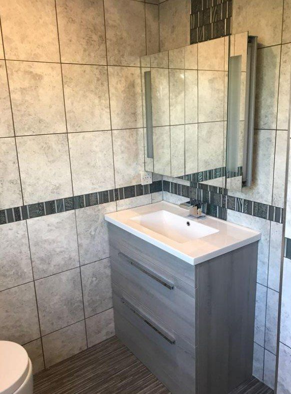 Picture of a new chrome effect tile bathroom suite fitted by Plumbers Sheffield and