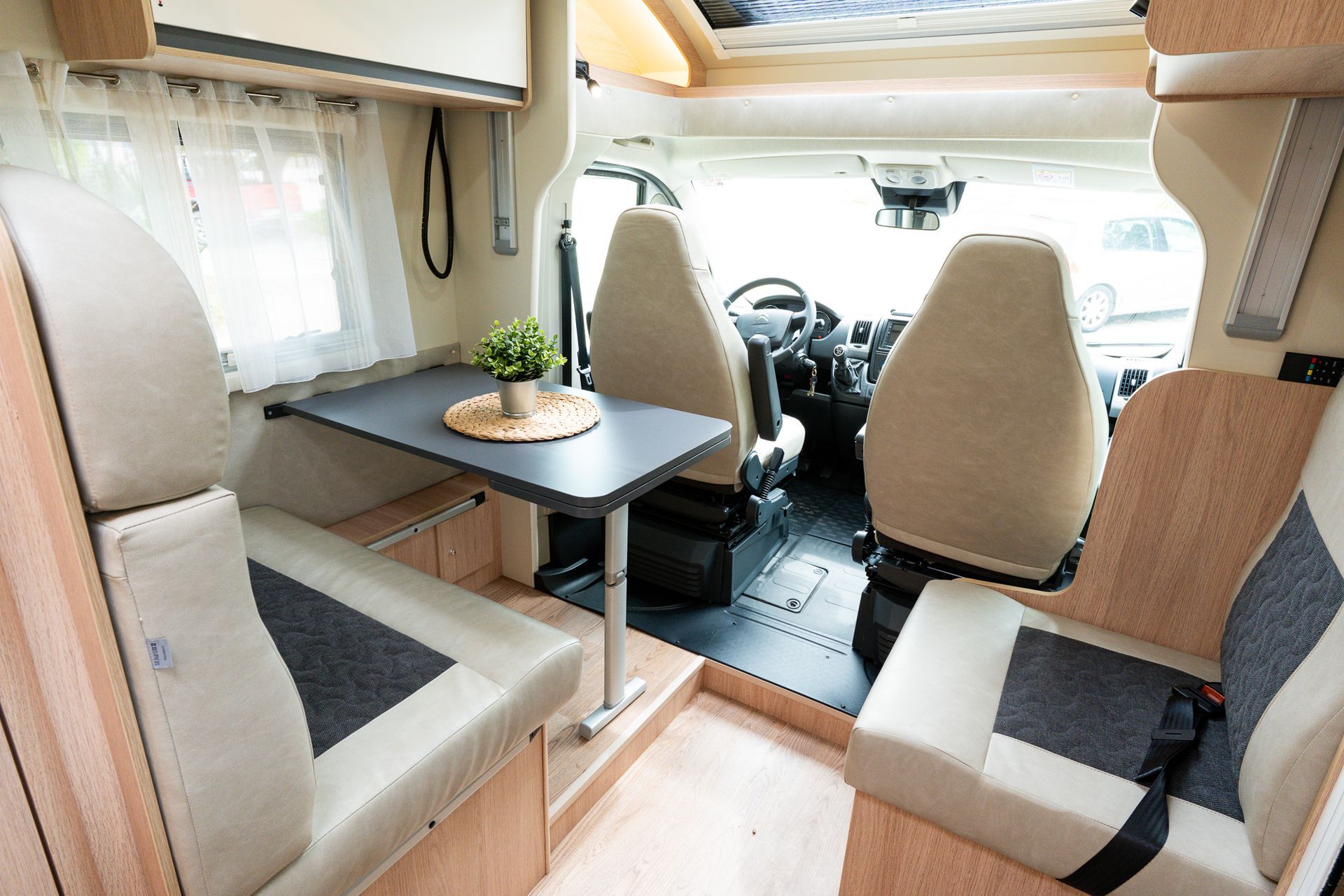 El interior de una furgoneta camper con una mesa y sillas.