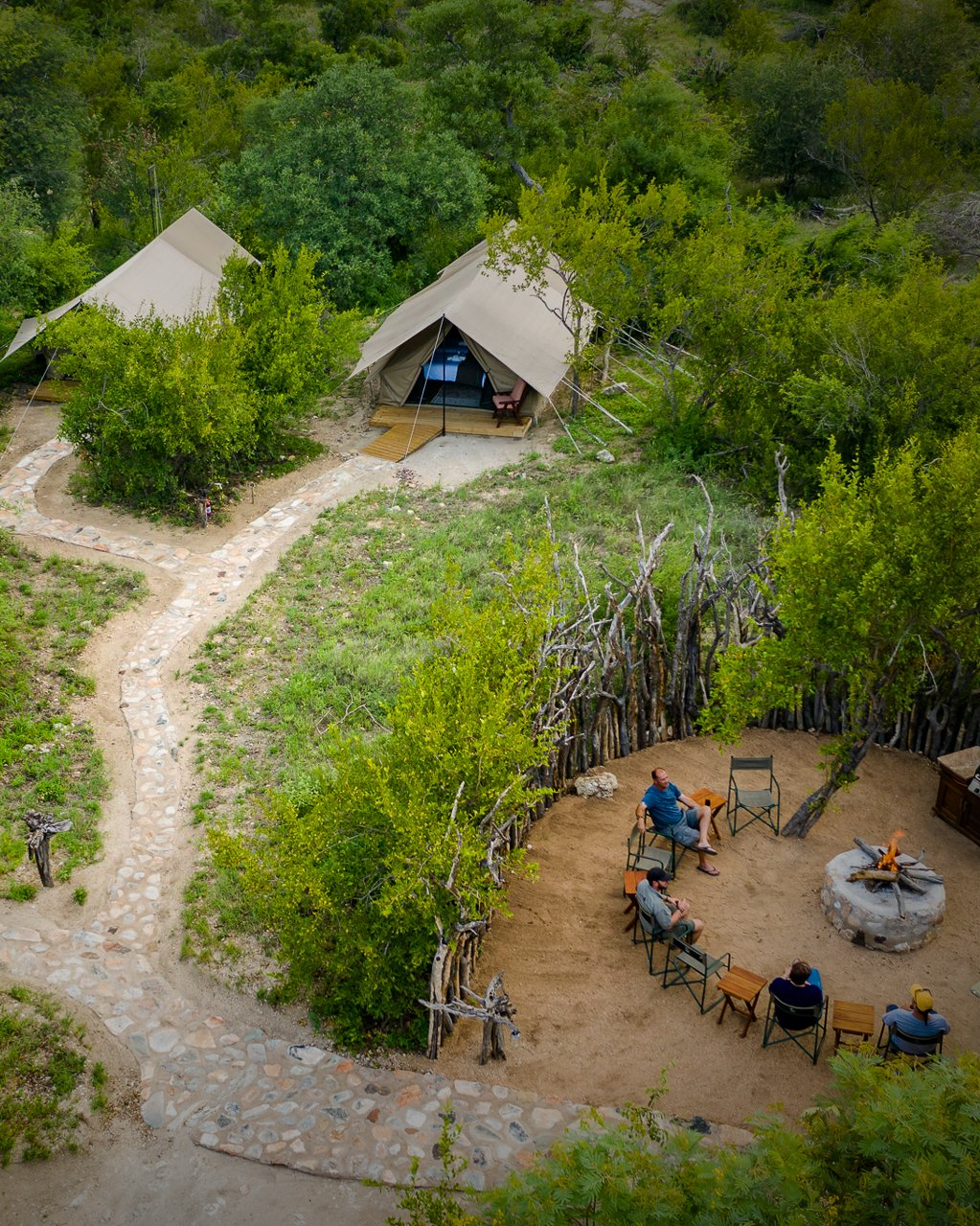 Aerial view of African safari camp with tents and guests in bushveld