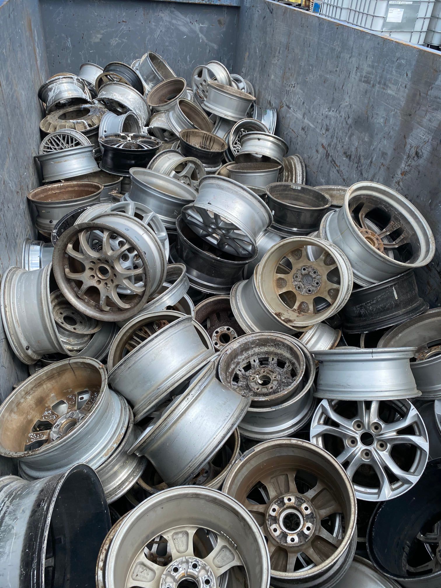 A Large Bin Filled With A Pile Of Used, Silver-colored Car Rims — H&H Metal Recycling in Kenilworth, QLD