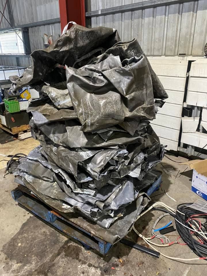 Stack Of Crumpled, Gray Metal Sheets On A Wooden Pallet, Likely For Recycling — H&H Metal Recycling in Kenilworth, QLD