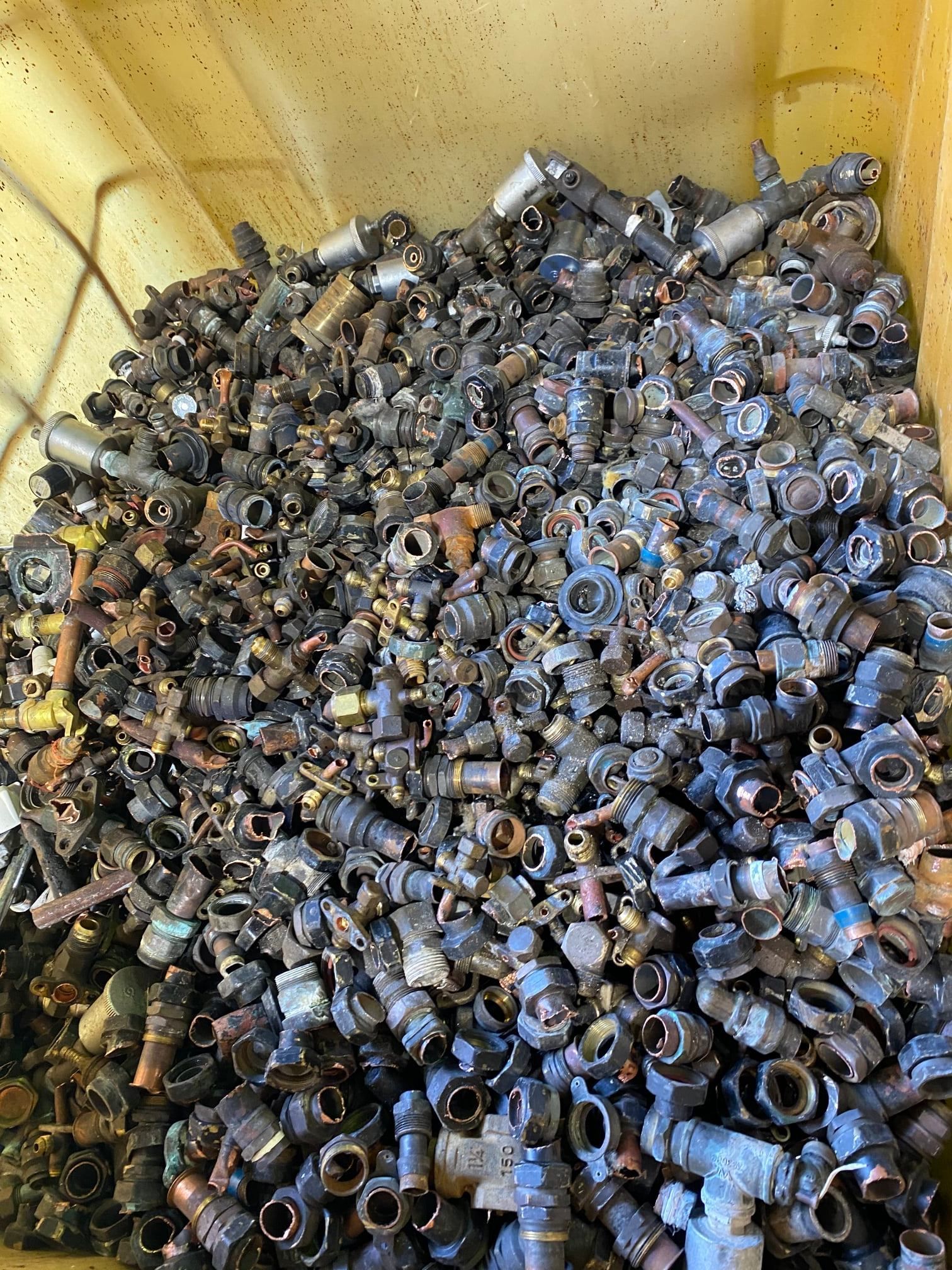 A Bin Overflowing With Many Small, Metal Plumbing Fittings, Mostly Dark In Color — H&H Metal Recycling in Kenilworth, QLD