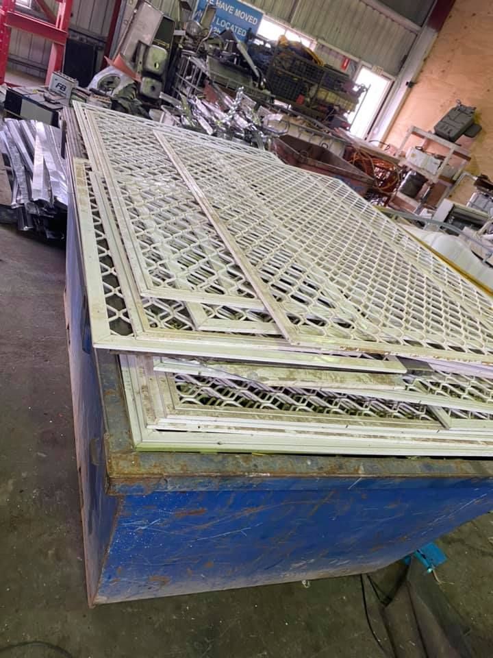 Sheets Of White Patterned Metal Stacked On A Blue Industrial Container — H&H Metal Recycling in Maleny, QLD