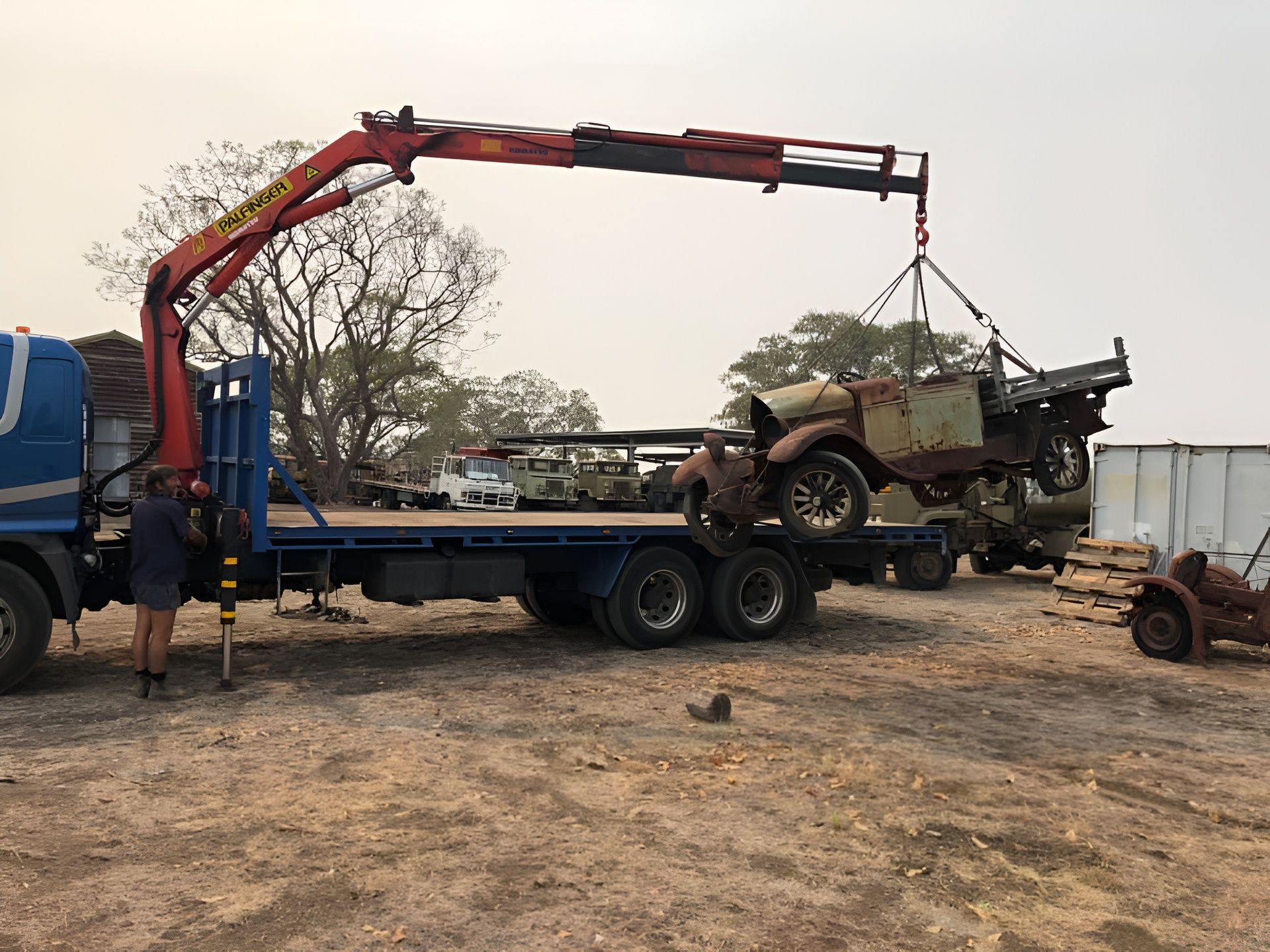 A Rusty Vintage Truck Is Lifted By A Crane Onto A Flatbed Truck, Outdoors — H&H Metal Recycling in Pelican Waters, QLD
