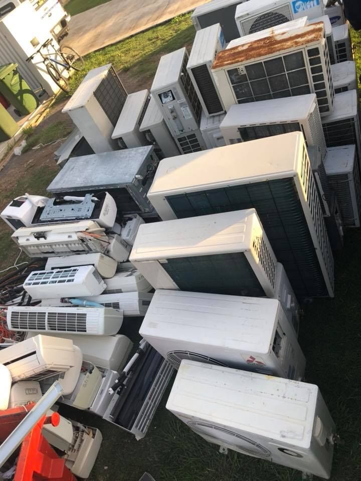 Pile Of Discarded Air Conditioning Units On Grassy Ground — H&H Metal Recycling in Bells Creek, QLD