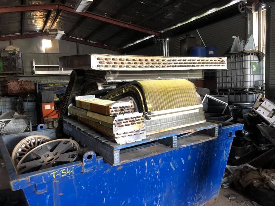 Metal Coils And Radiators Piled In A Blue Industrial Dumpster — H&H Metal Recycling in Mudjimba, QLD