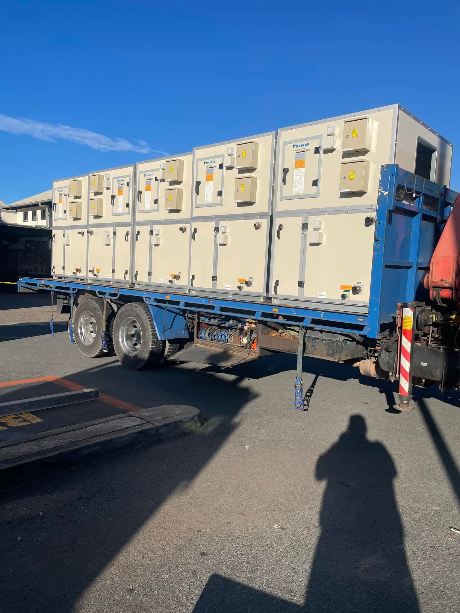 A Blue Flatbed Truck Carrying a Large, Beige Industrial Hvac Unit — H&H Metal Recycling in Caloundra West, QLD