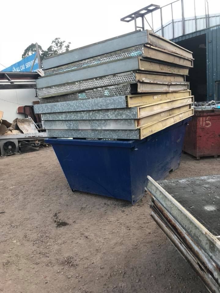 Blue Dumpster Overflowing With Metal And Foam Sandwich Panels — H&H Metal Recycling in Beerwah, QLD