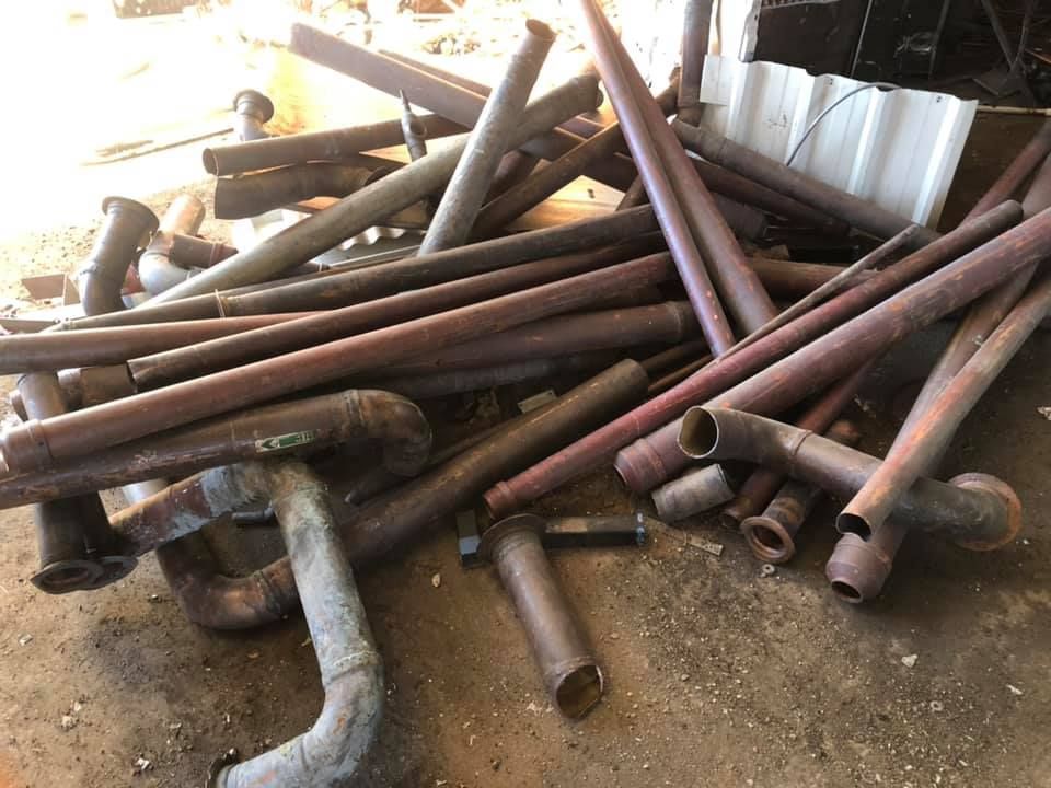 Pile Of Rusty Metal Pipes On A Concrete — H&H Metal Recycling in Glass House Mountains, QLD
