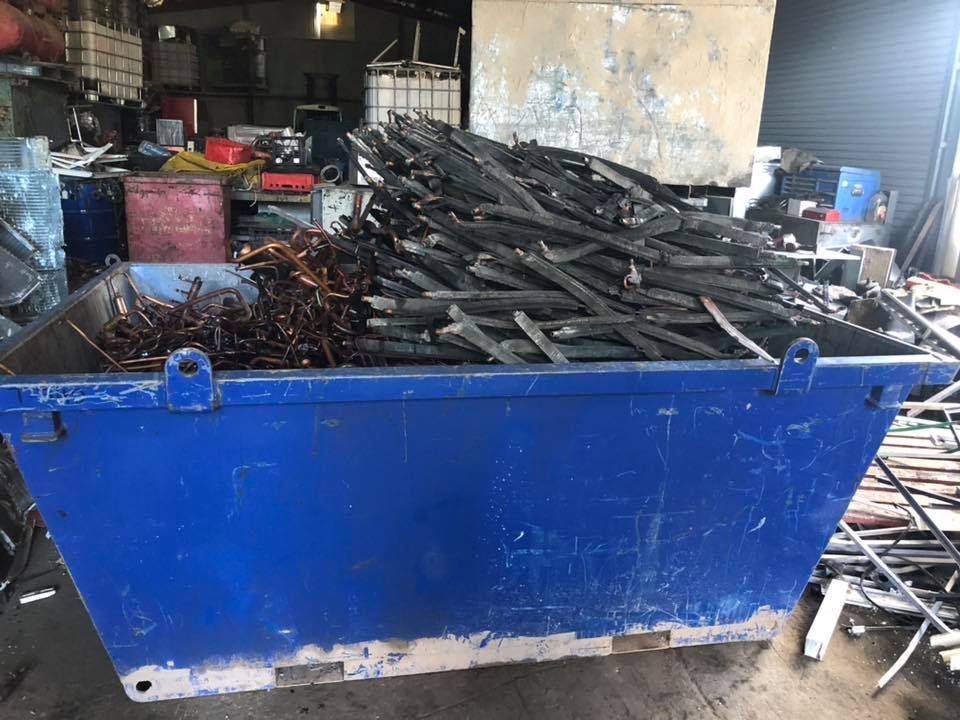 Blue Dumpster Overflowing With Scrap Metal, Including Copper Wire And Wood — H&H Metal Recycling in Moffat Beach, QLD