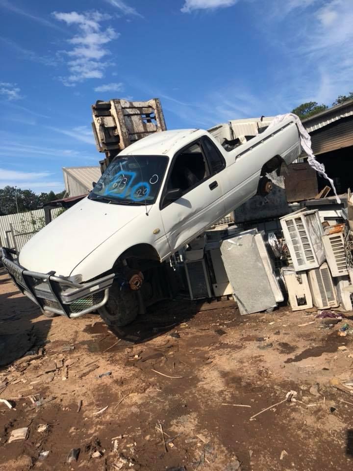 White Pickup Truck Crushed By Machinery At A Scrap Metal Yard — H&H Metal Recycling in Moffat Beach, QLD