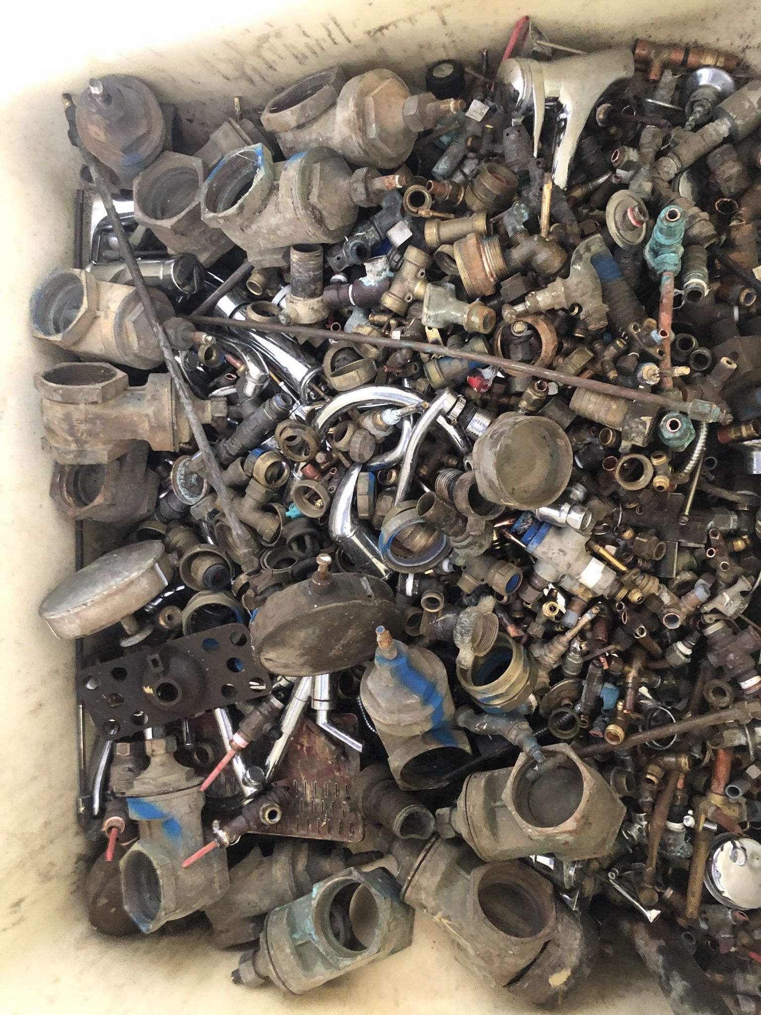 Scrap Metal Pile Including Pipes, Valves, And Fittings Inside A White Bin — H&H Metal Recycling in Gympie, QLD