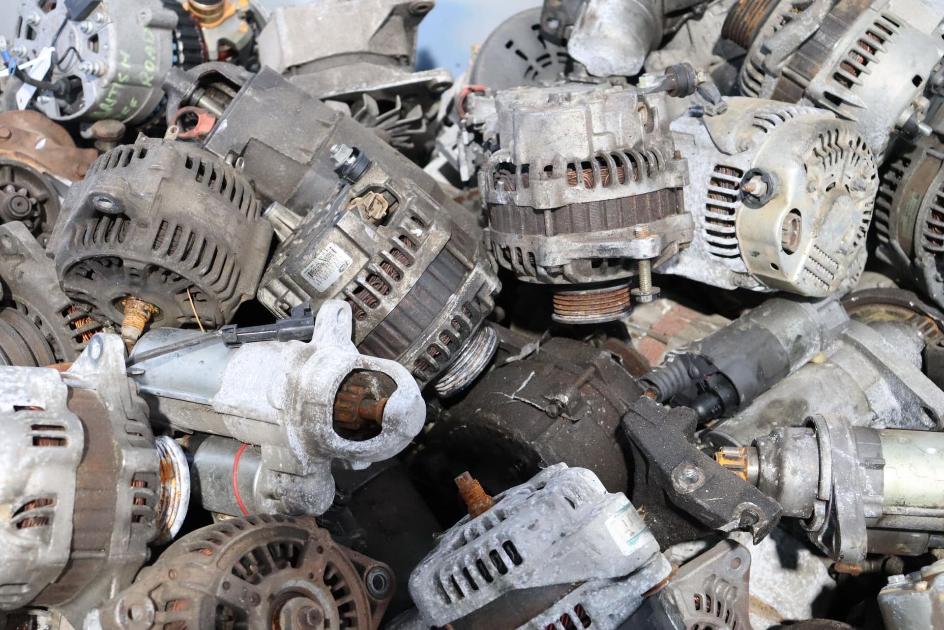 Pile Of Used Car Alternators, Mostly Silver And Gray, Outdoors — H&H Metal Recycling in Gympie, QLD