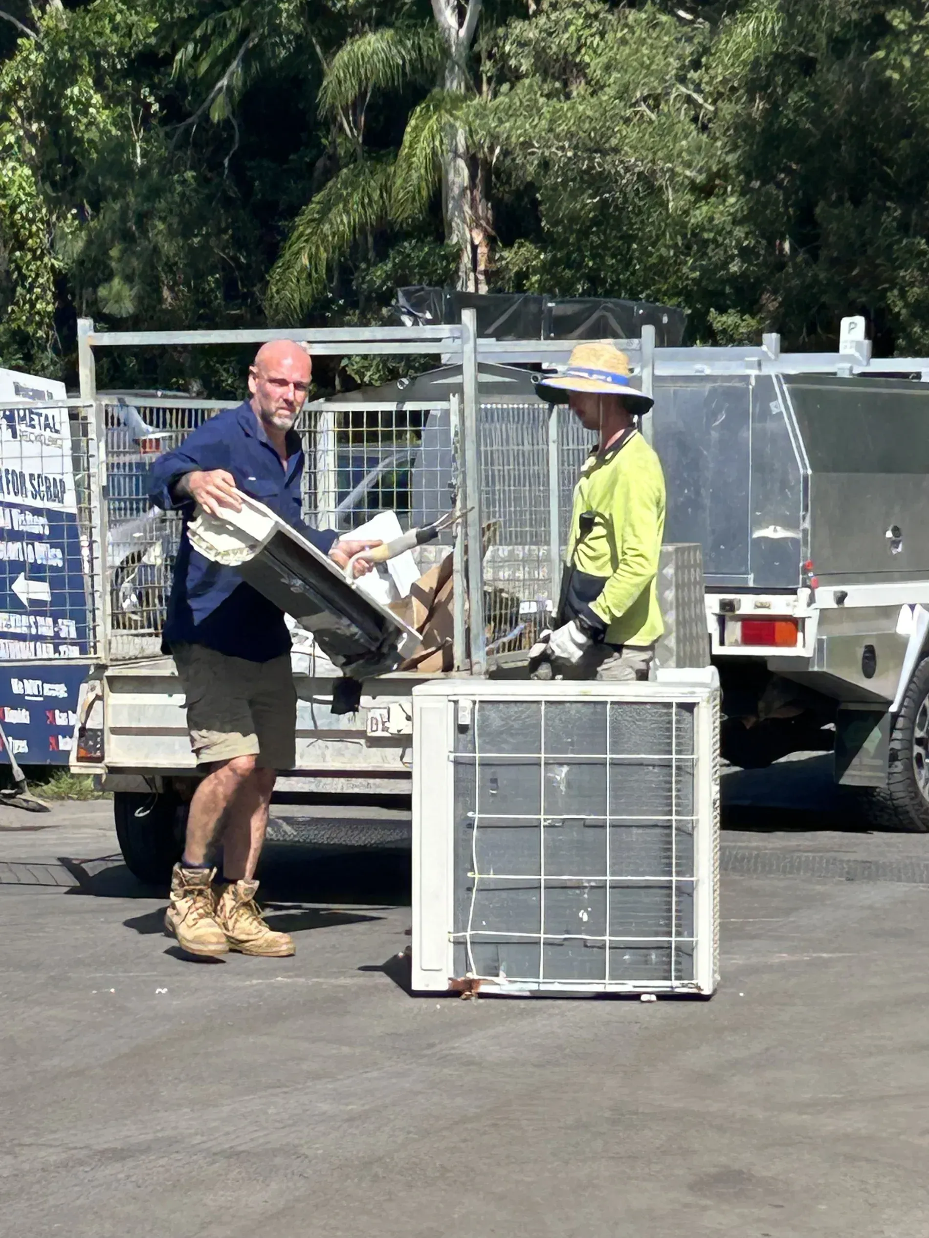 Two Workers Load Equipment From a Truck — H & H Metal Recycling In Cooroy, QLD