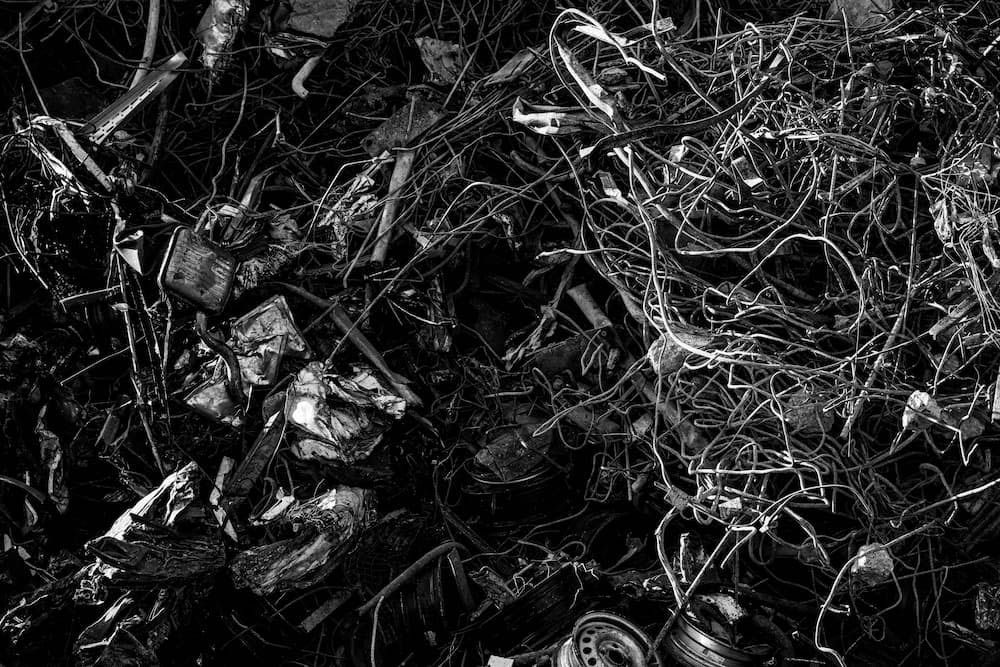 Close-up of twisted metal wires and crushed scrap pieces, creating a chaotic texture.