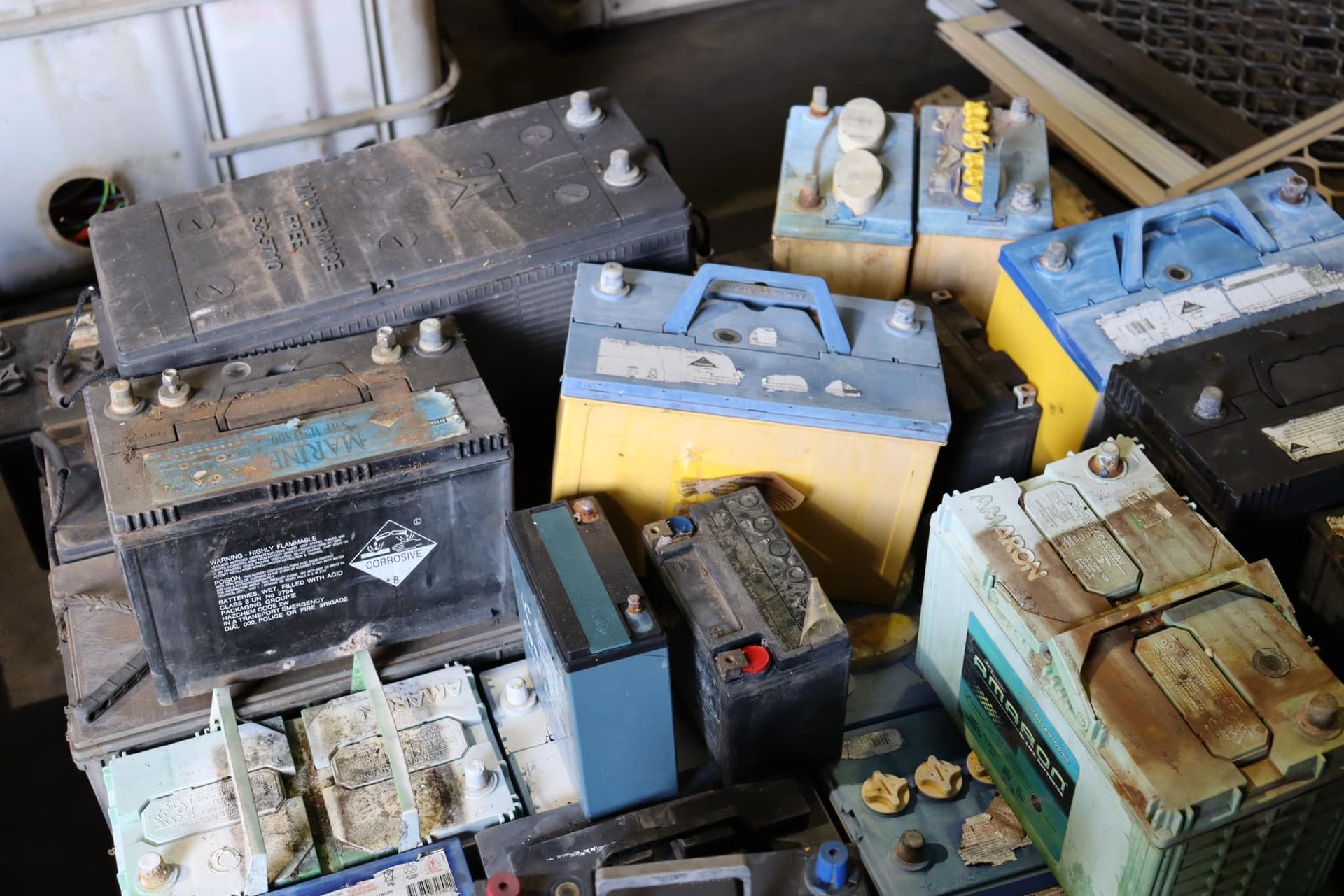 Old Dusty Car Batteries Stacked In Dim Area
