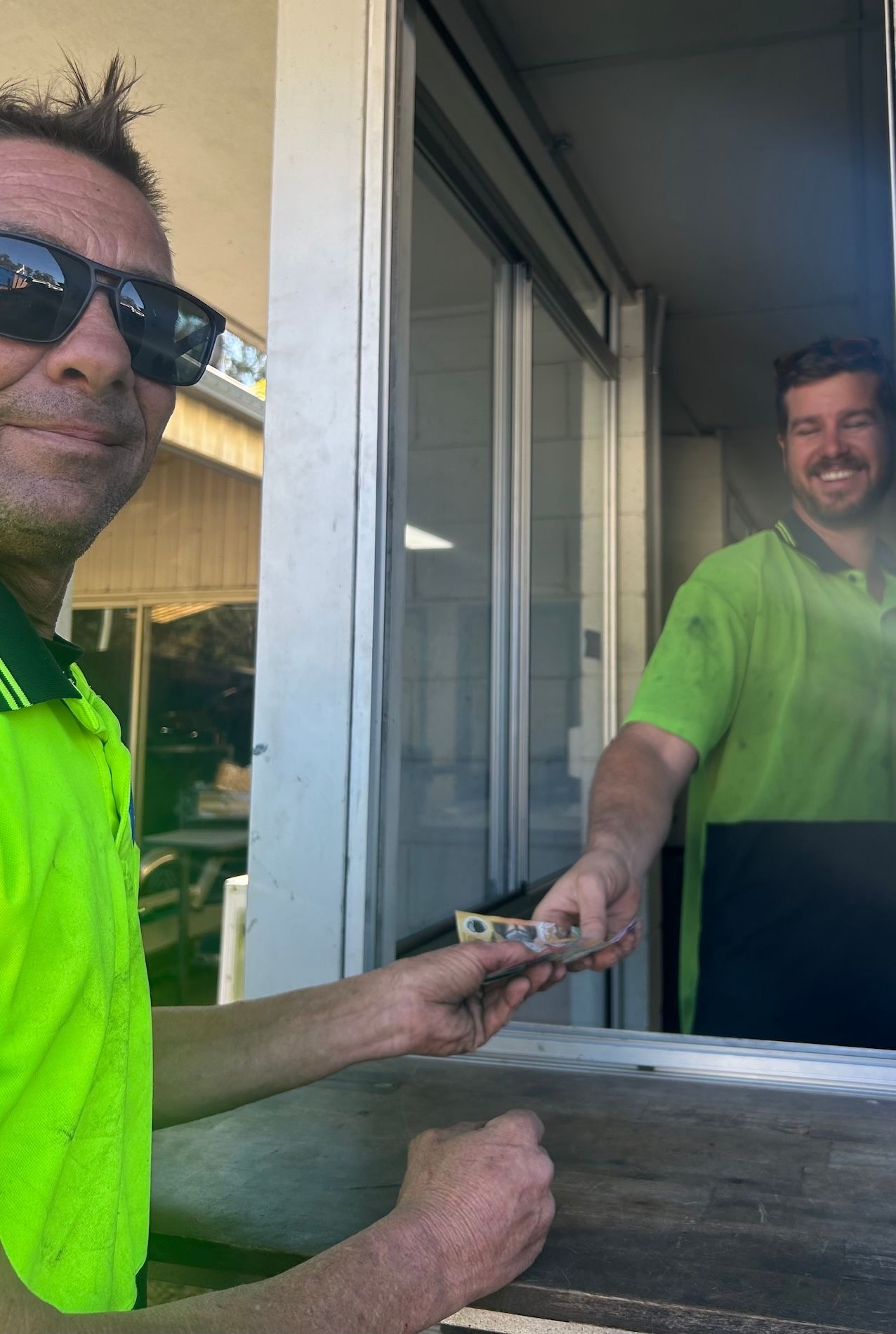Men Receiving Cash After Dropping Off Scrap Metal — H & H Metal Recycling In Kunda Park, QLD