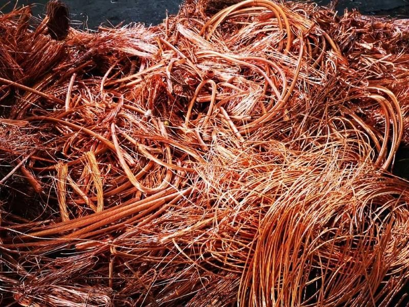 A Pile of Copper Wire Is Laying on A Black Surface — H & H Metal Recycling In Landsborough, QLD