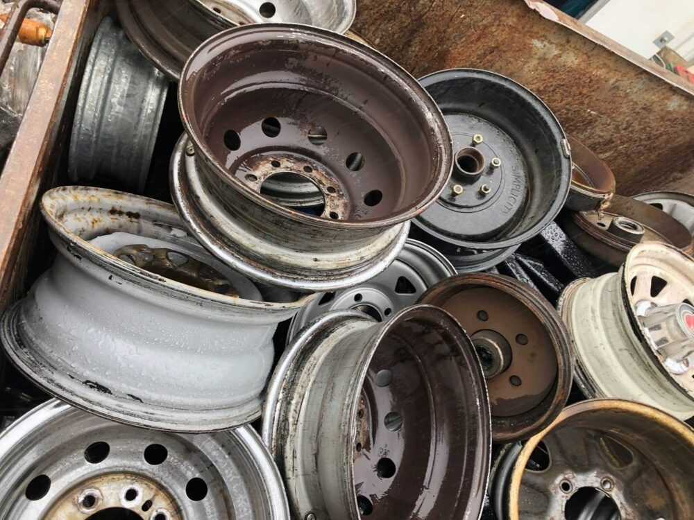 A Pile of Wheels Are Stacked on Top of Each Other — H & H Metal Recycling In Noosa, QLD