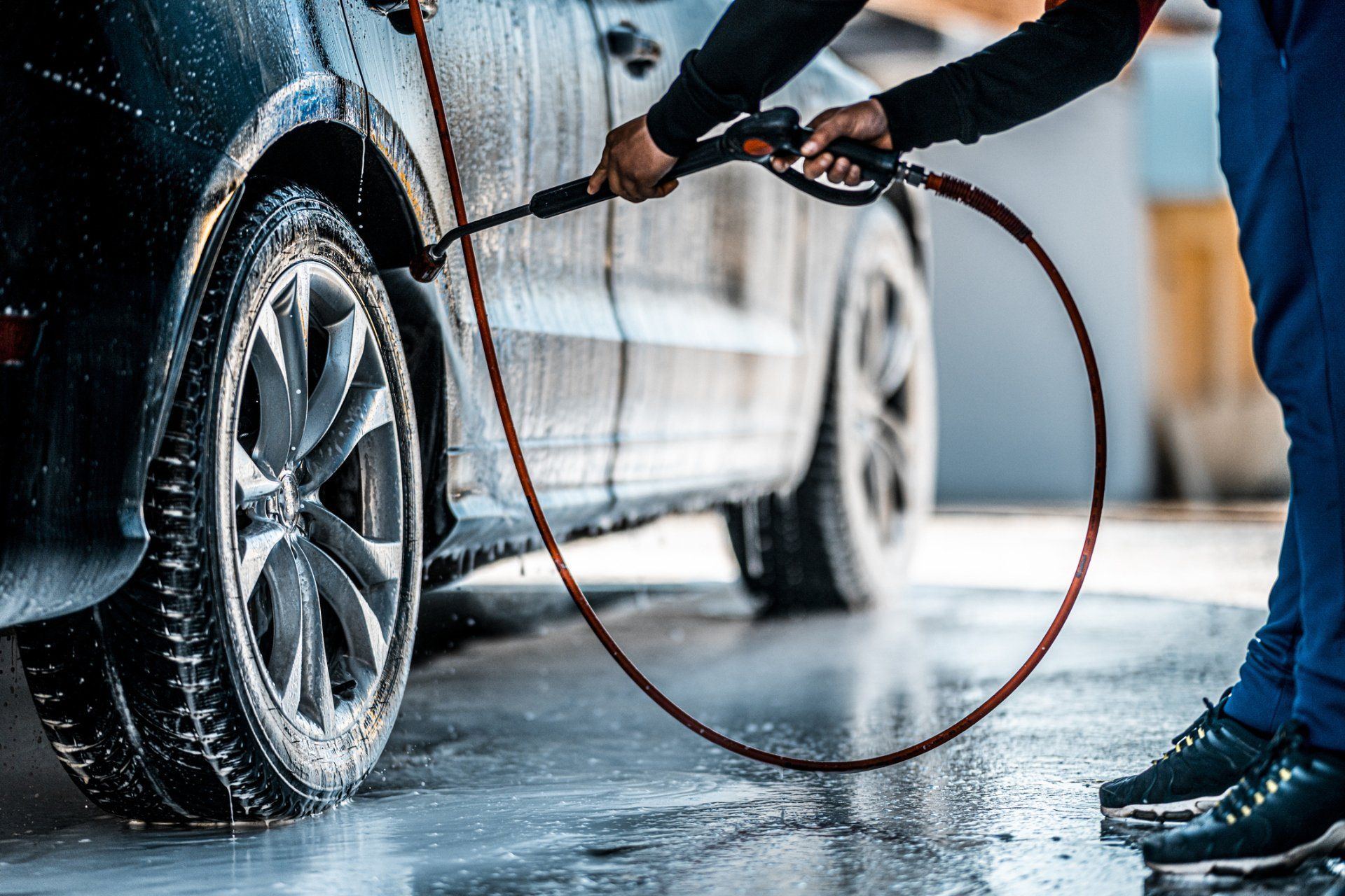 Man Cleaning A Dirty Wheel — Lenexa, KS — Lenexa Car Wash