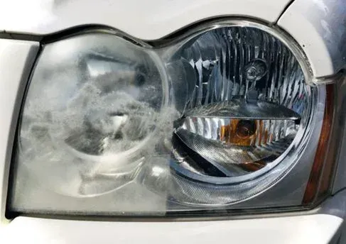 A close up of a car headlight before and after being cleaned.