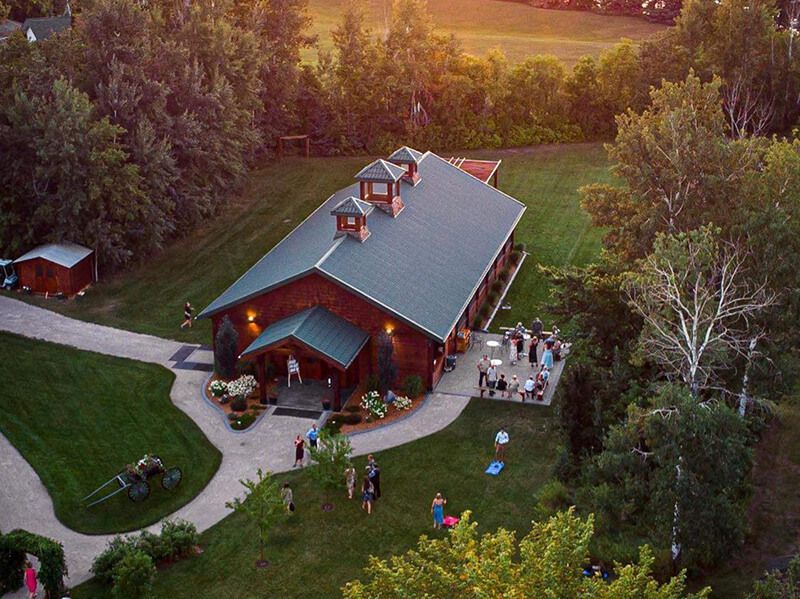 Tarot cards on a wooden table, lit candle, leafy branches, and card displaying two nude figures.
