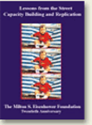 A child and a uniformed police officer stand in front of a police station with glass doors.