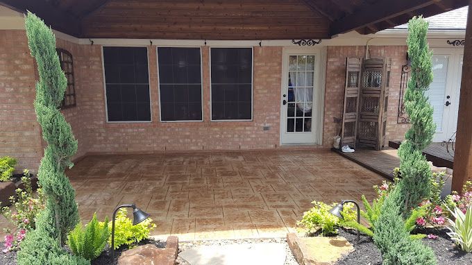 Brick house front porch with tiled patio, white door, screened windows, and landscaped walkway