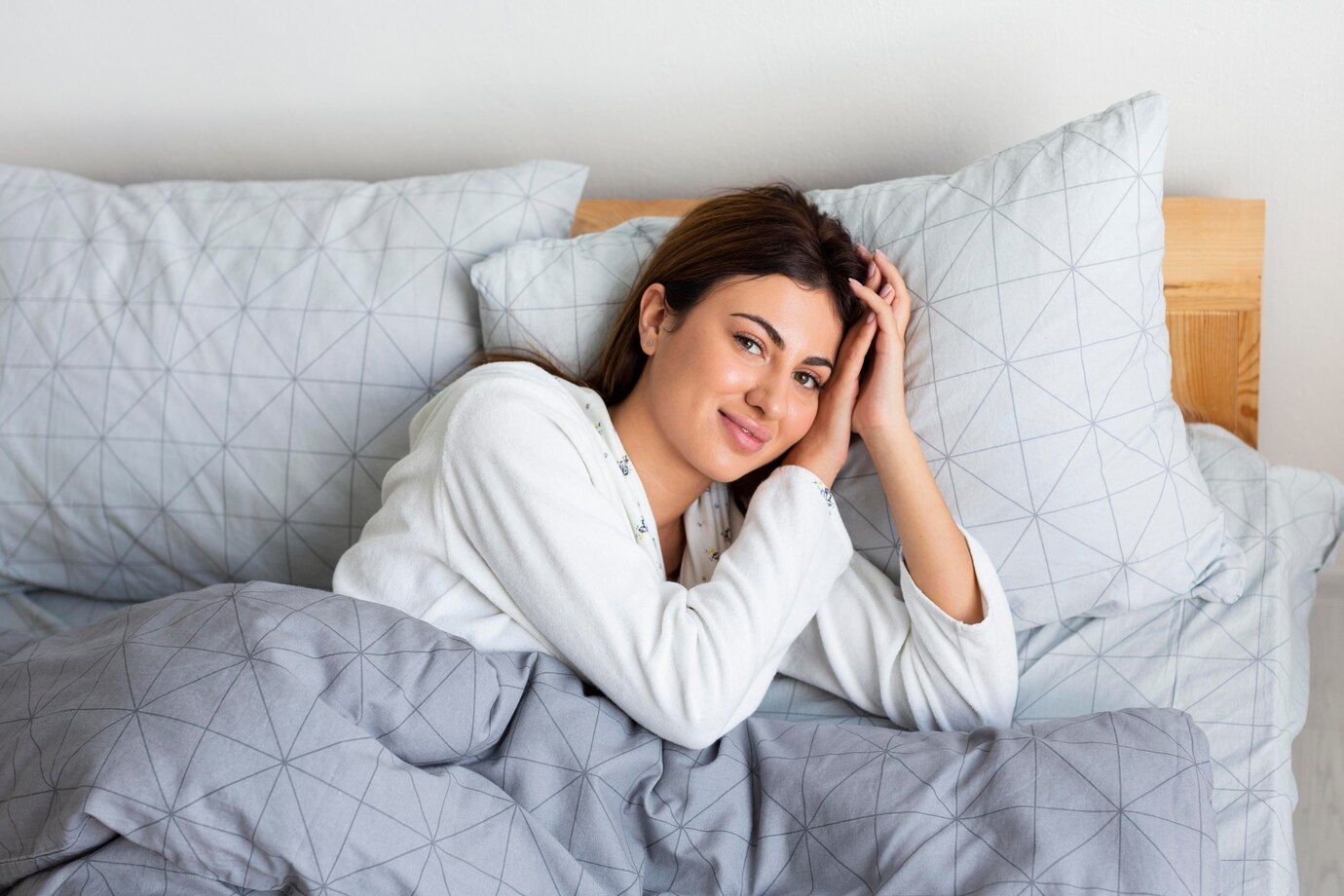 A woman with good sleep hygiene is laying in bed.