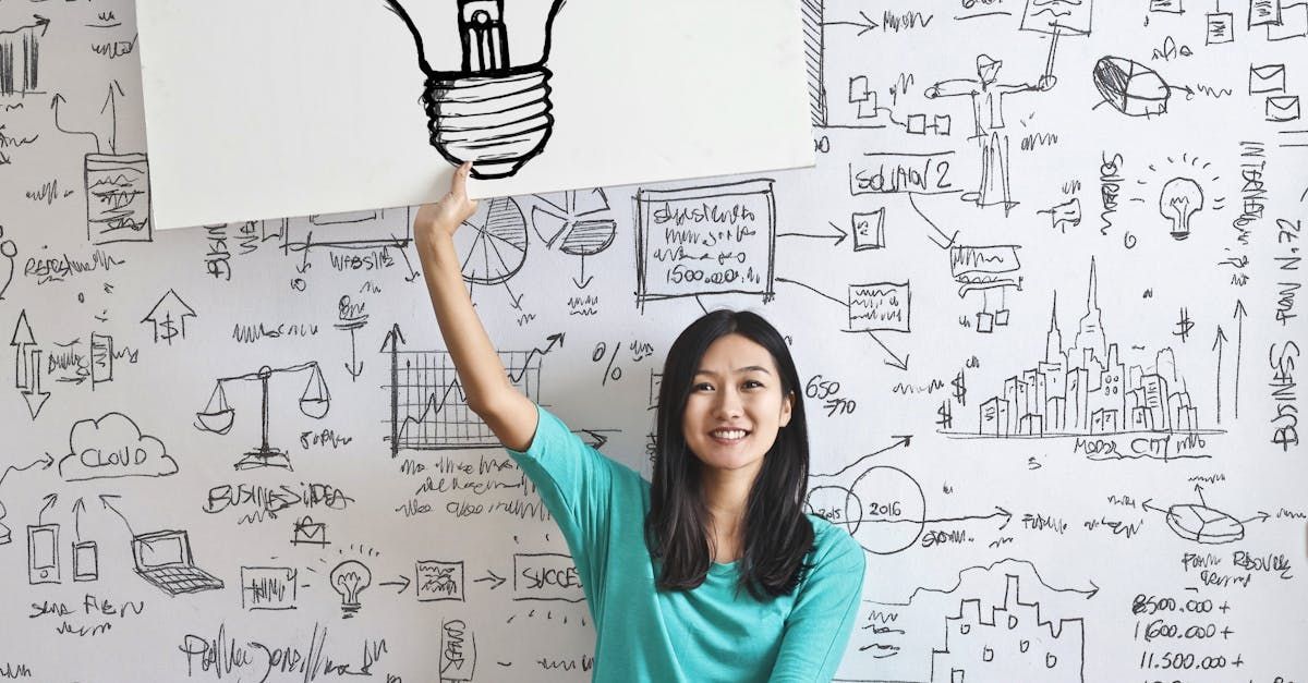 A woman is holding a sign over her head with a light bulb drawn on it.