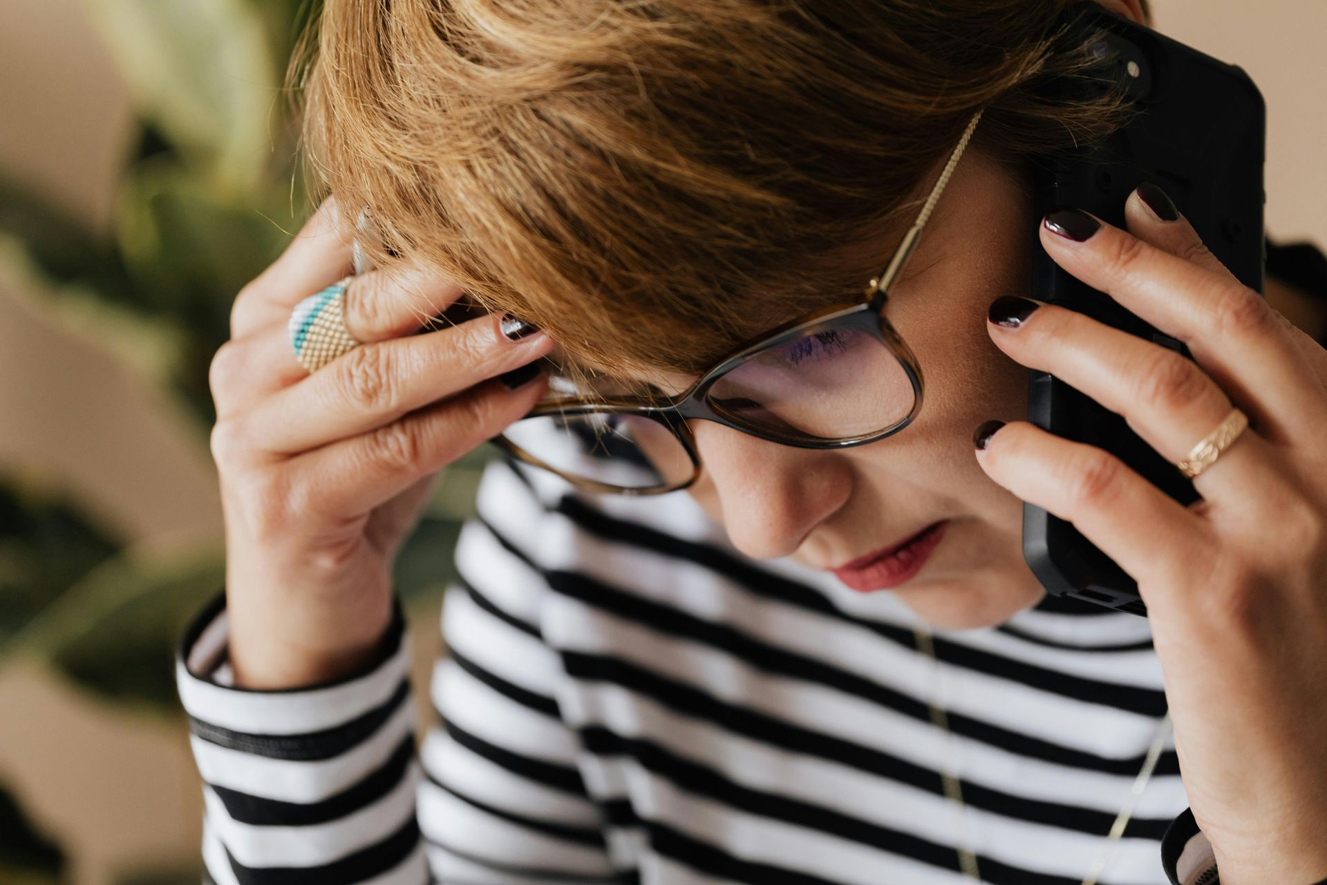 A woman wearing glasses is talking on a cell phone.