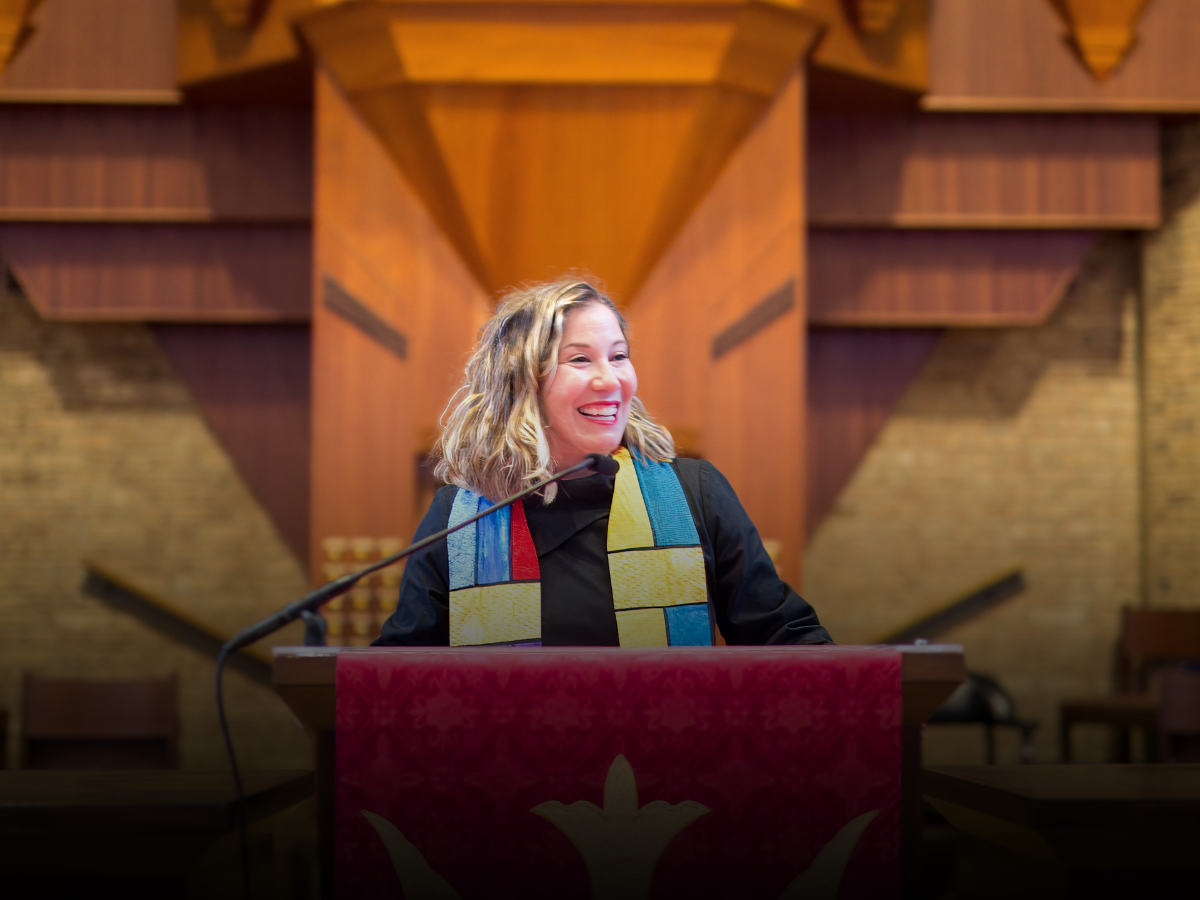 A woman is giving a speech at a podium in a church.