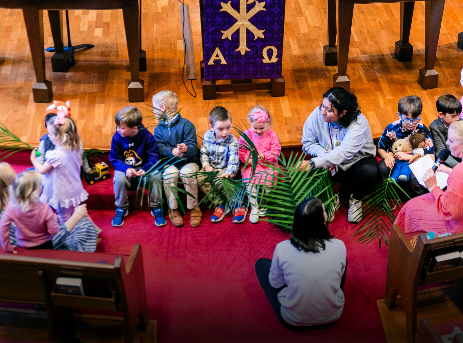 A group of children are sitting on the floor in a church.