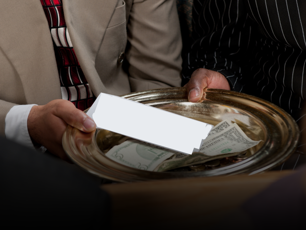A man is holding a tray of money and a piece of paper