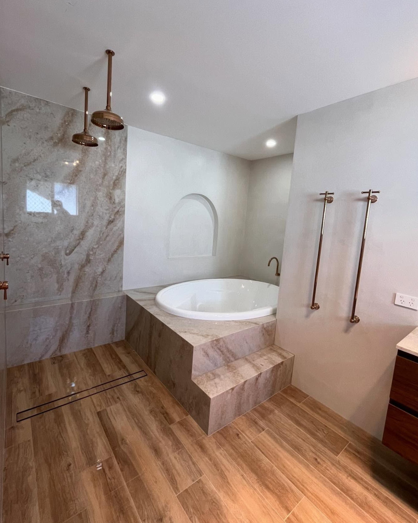 Bathroom With Round Tub on Raised Platform, Tiled Shower, and Copper Fixtures — Cobra Plumbing & Bathrooms in Heathcote, NSW