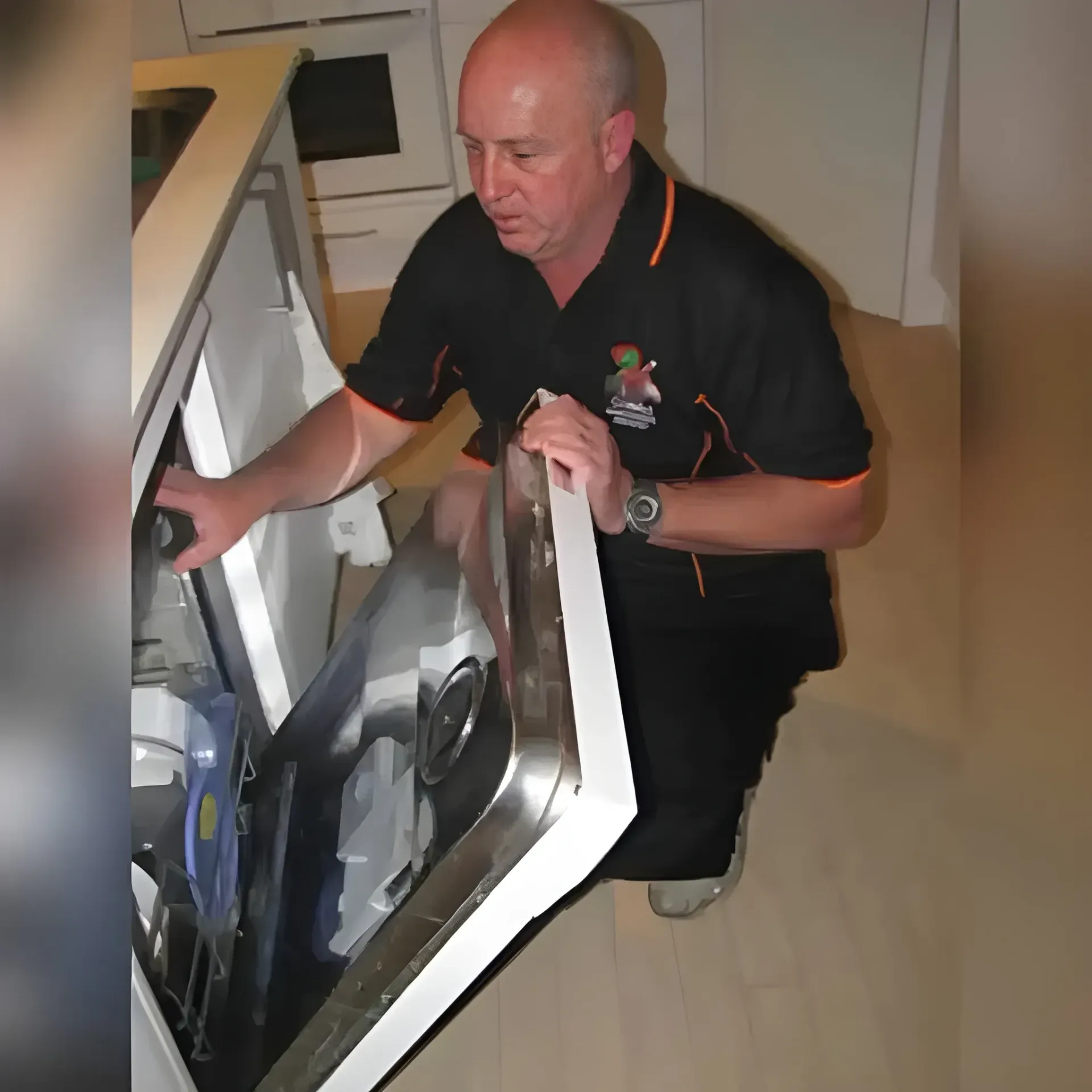 Man Inspecting a Dishwasher. He Kneels and Opens the Door — Cobra Plumbing & Bathrooms in Heathcote, NSW