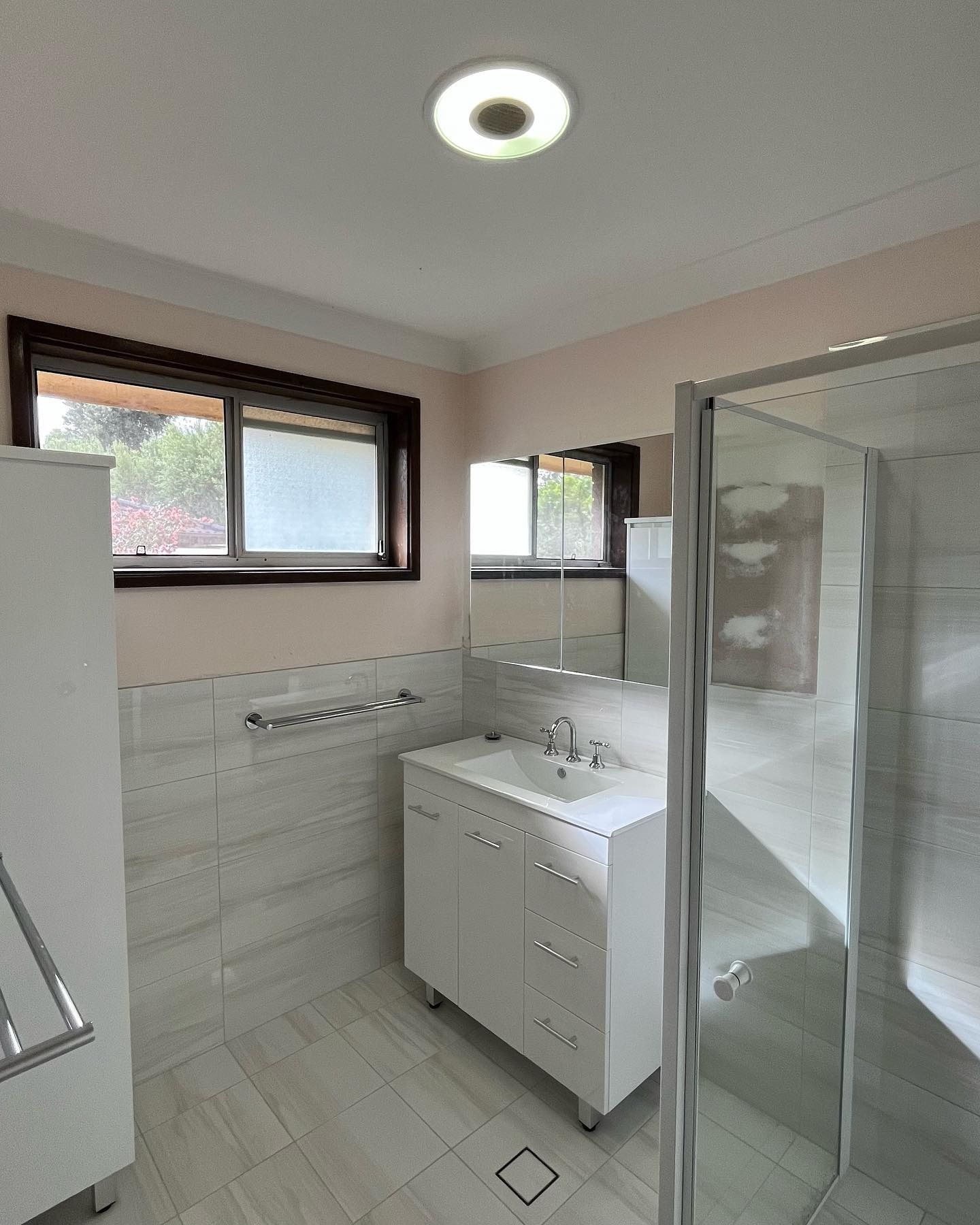 Bathroom with White Cabinets, Shower, Window — Cobra Plumbing & Bathrooms in Heathcote, NSW