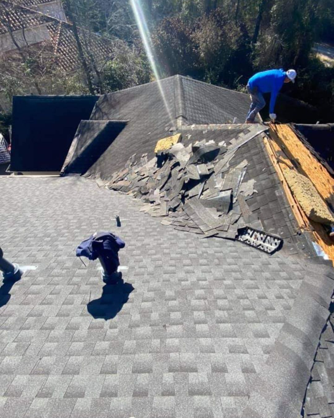 A man is working on the roof of a house.