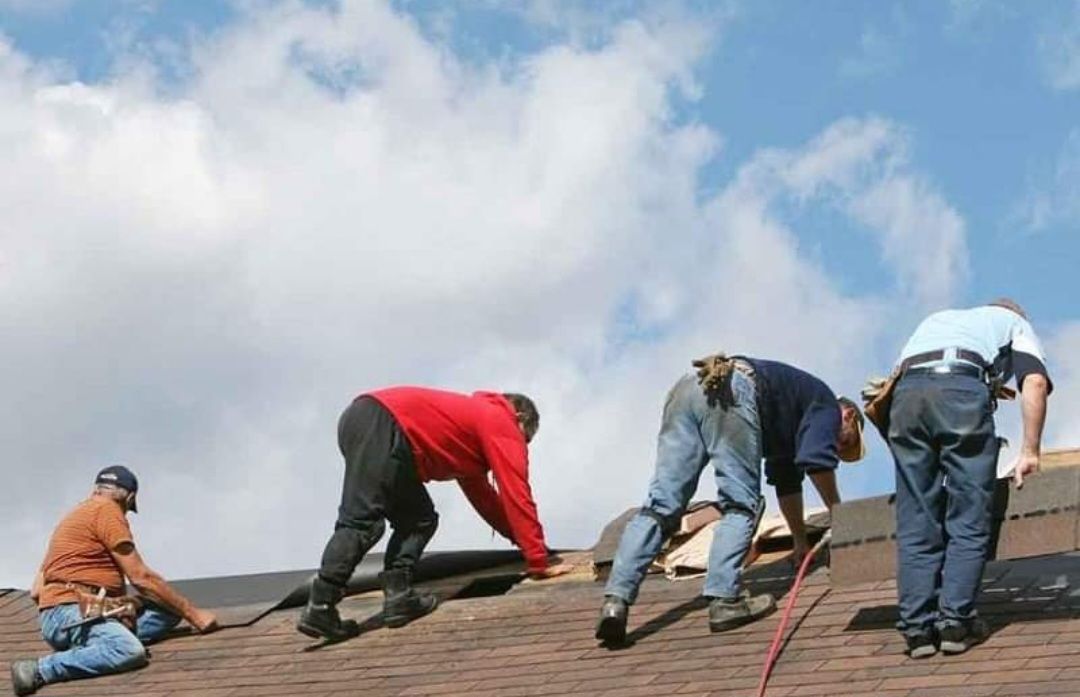 A group of men are working on a roof.