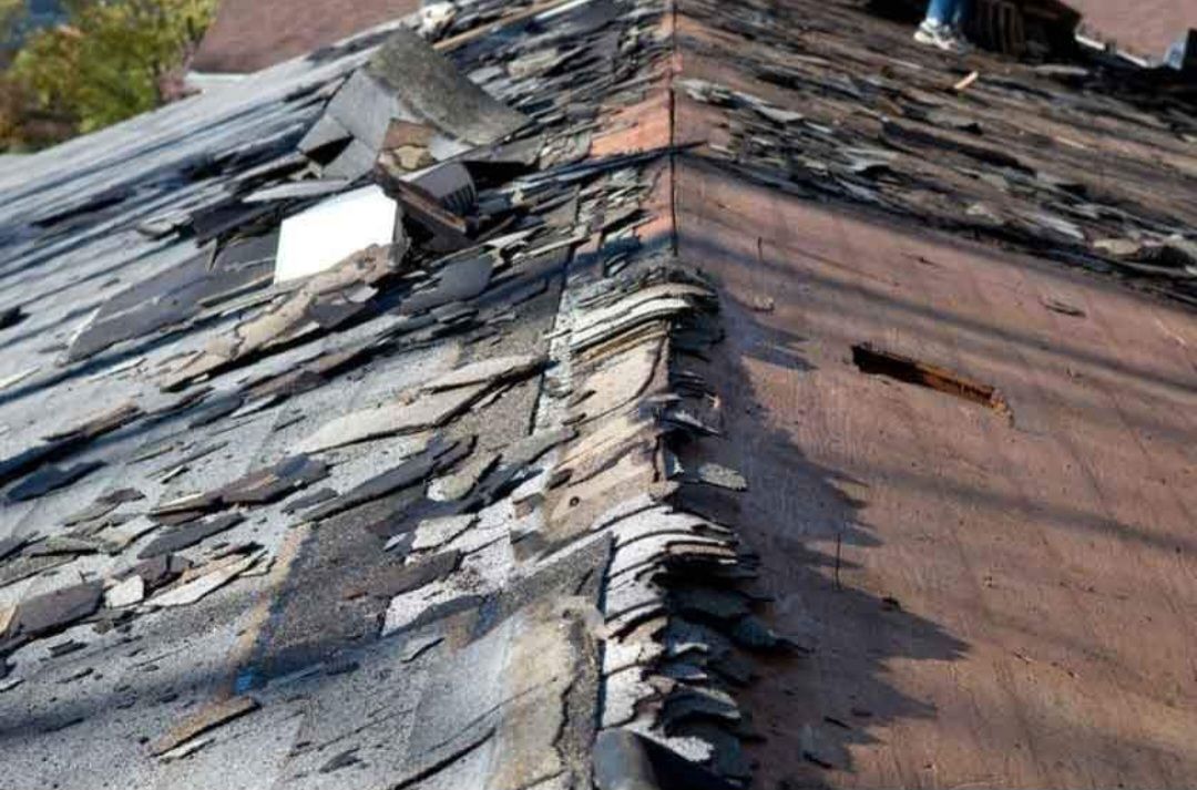 A roof with a lot of shingles on it is being repaired.