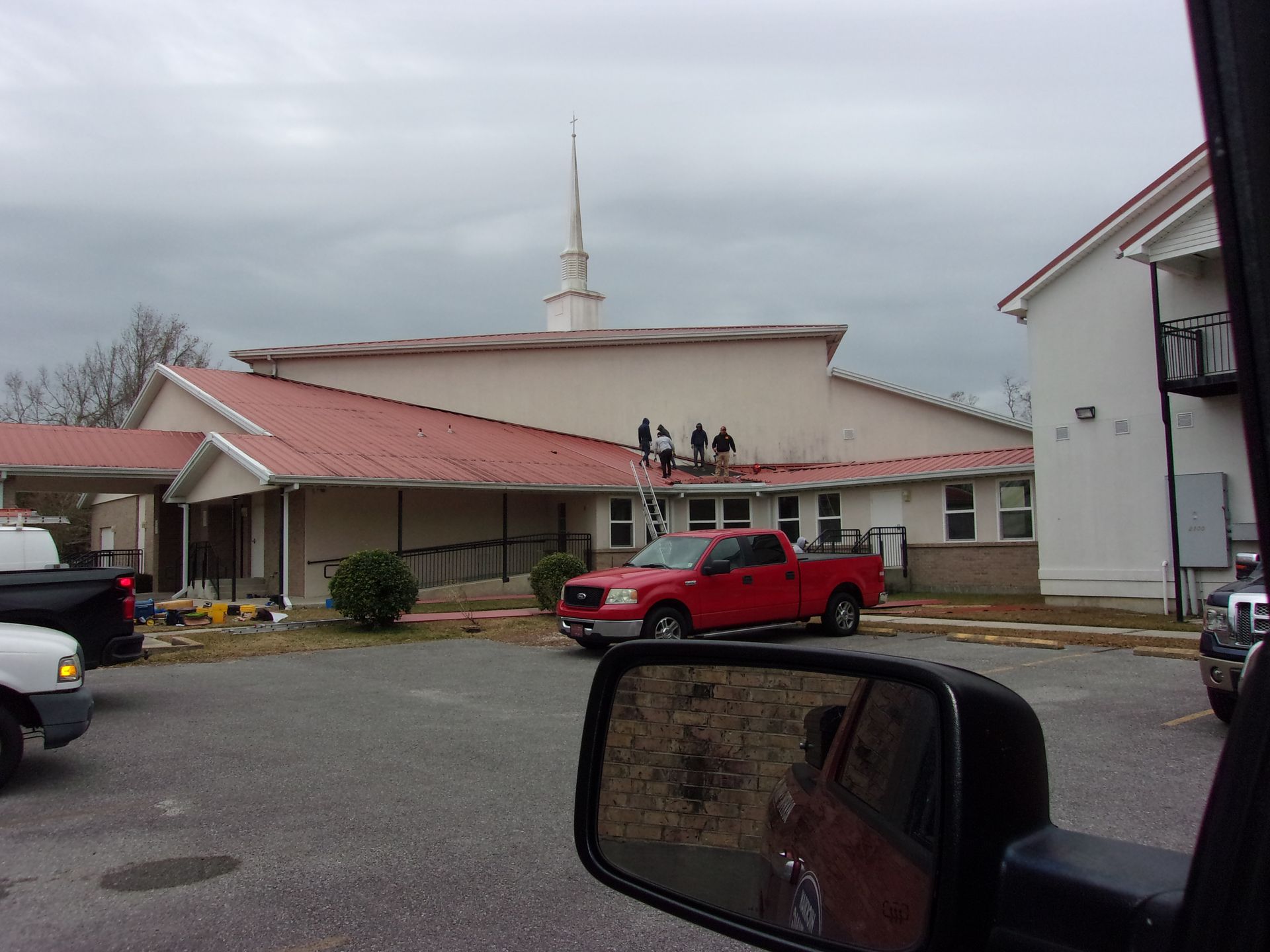 A red truck is parked in front of a church