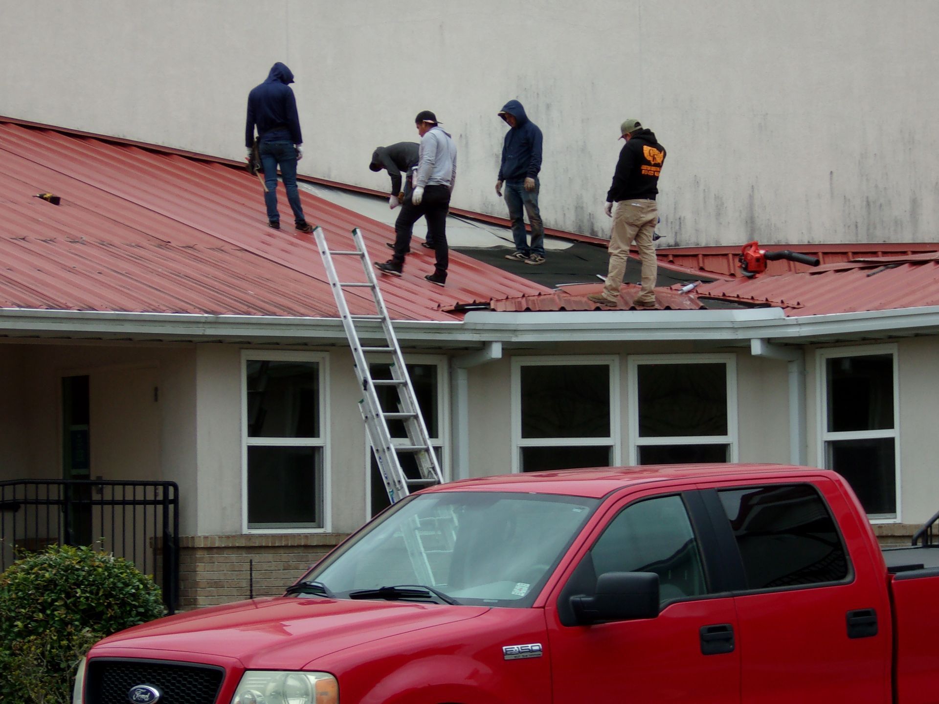 A group of men are working on the roof of a house.