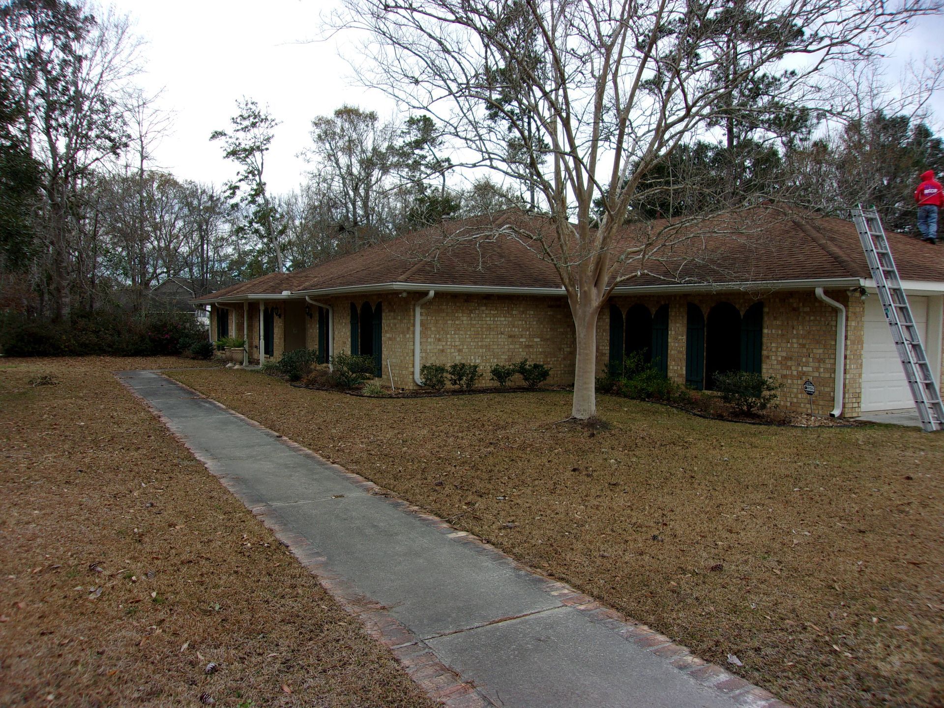A man is standing on the roof of a house.