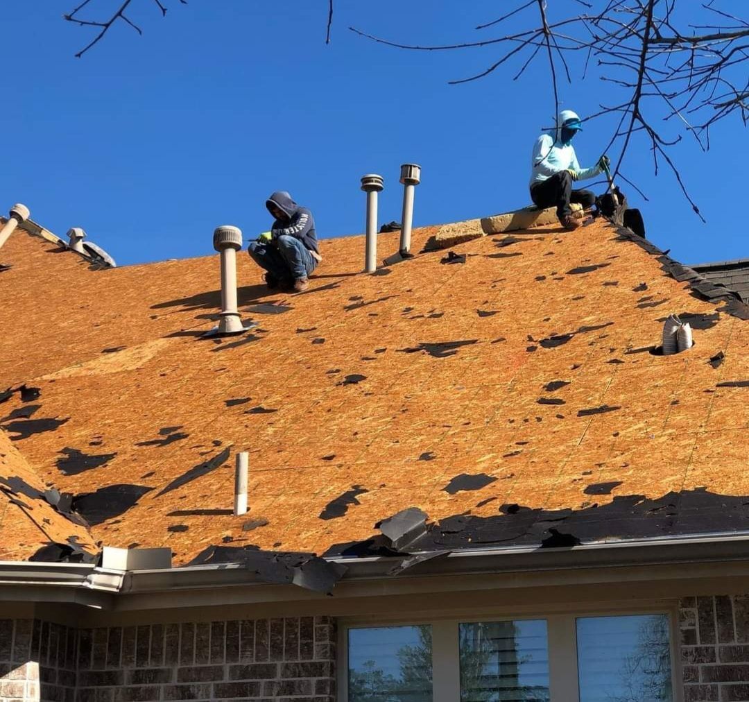 Two men are working on the roof of a house