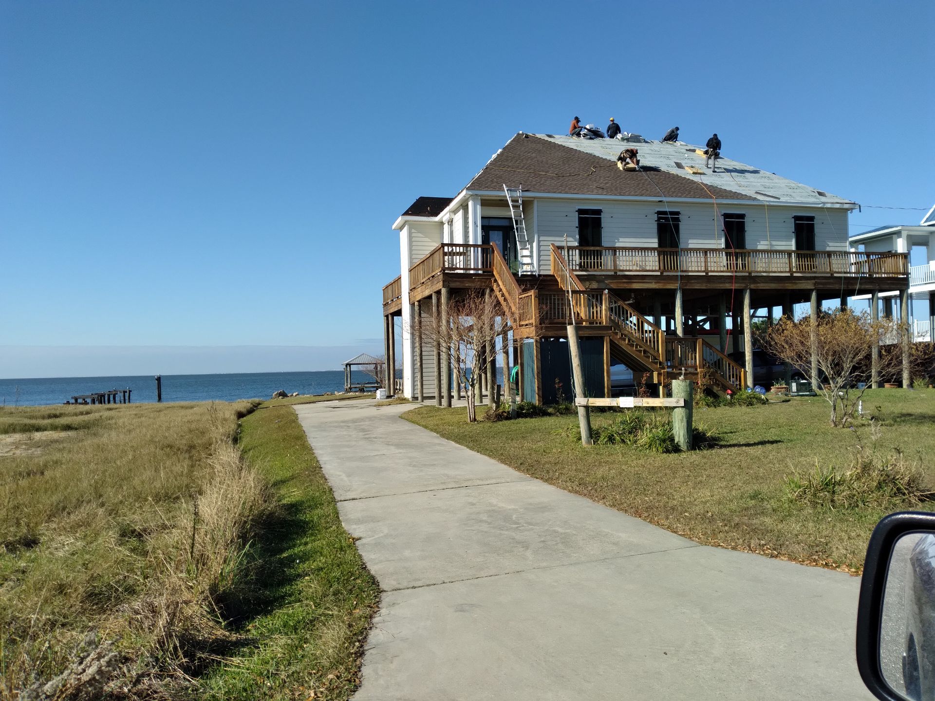 A house on stilts with a roof that is being repaired.
